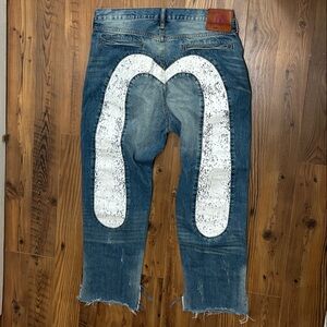 Evisu distressed denim jeans featuring an Ecru Daicock print on the back pockets